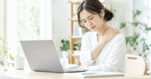 デスクワーク中に肩を押さえる30代女性のイメージ、または和の施術空間